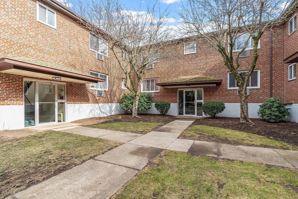 26 Bryon Road, Unit 3 Boston, MA 02467 - Photo 21 of 30 a front view of a house with a yard and garage