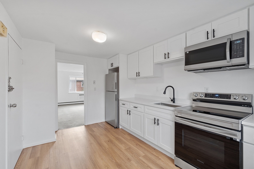 26 Bryon Road, Unit 3 Boston, MA 02467 - Photo 3 of 30 a kitchen with stainless steel appliances a stove microwave and sink