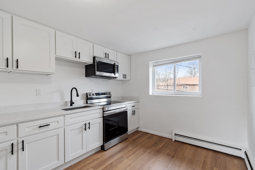 26 Bryon Road, Unit 3 Boston, MA 02467 - Photo 4 of 30 a kitchen with a sink cabinets and wooden floor