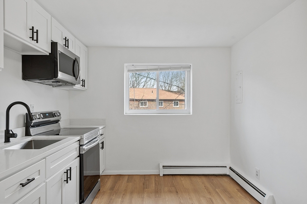 26 Bryon Road, Unit 3 Boston, MA 02467 - Photo 6 of 30 a view of a kitchen with wooden floor and a sink