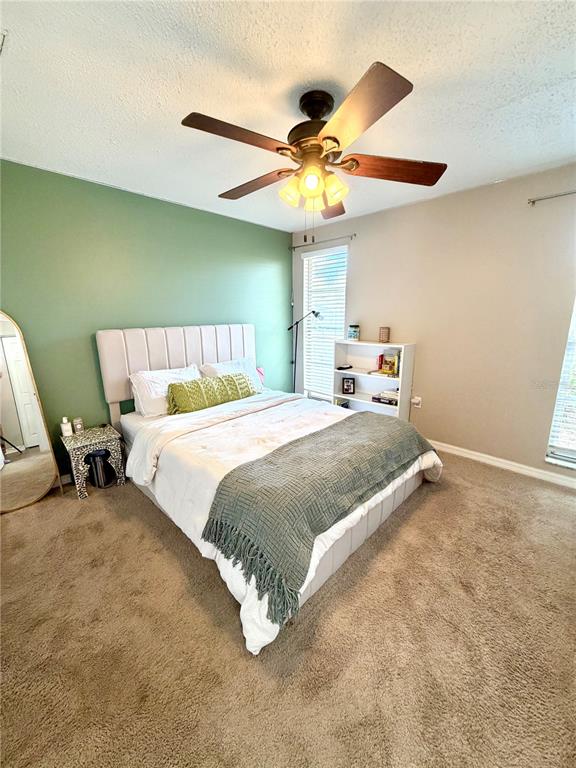 7974 Avenal Loop New Port Richey, FL 34655 - Photo 11 of 23 a bedroom with a bed and a ceiling fan