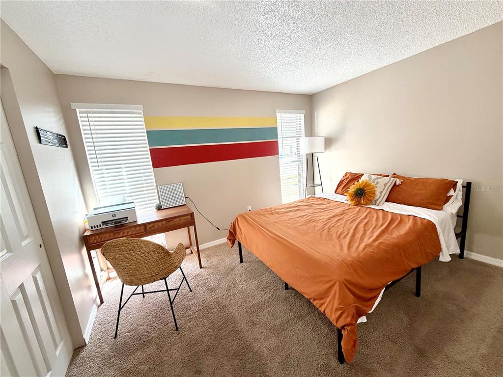 7974 Avenal Loop New Port Richey, FL 34655 - Photo 14 of 23 a bedroom with a bed and chair