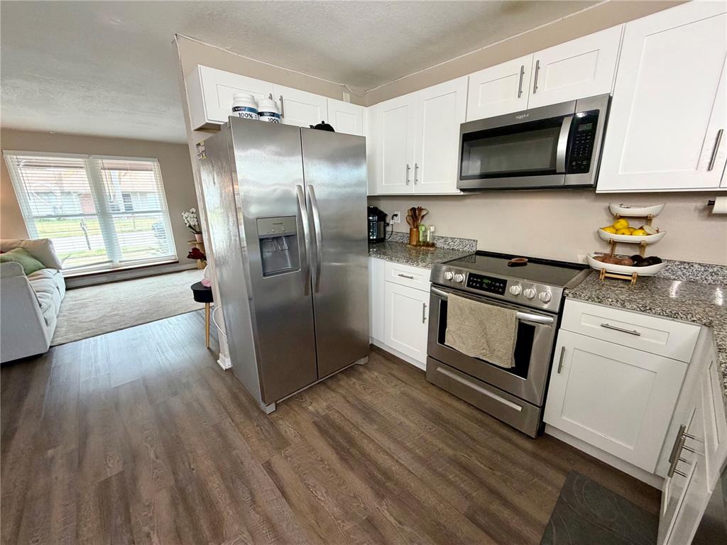 7974 Avenal Loop New Port Richey, FL 34655 - Photo 8 of 23 a kitchen with stainless steel appliances a refrigerator microwave and sink