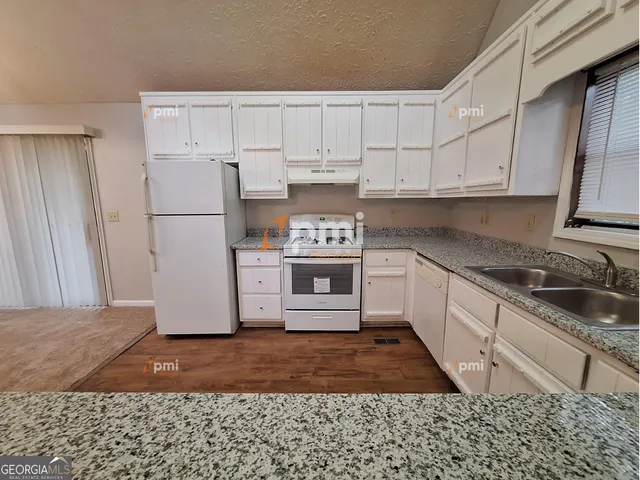 a kitchen with a refrigerator sink and cabinets