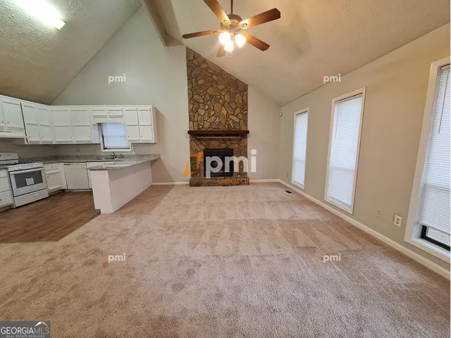 a open kitchen with stainless steel appliances granite countertop a stove and a refrigerator