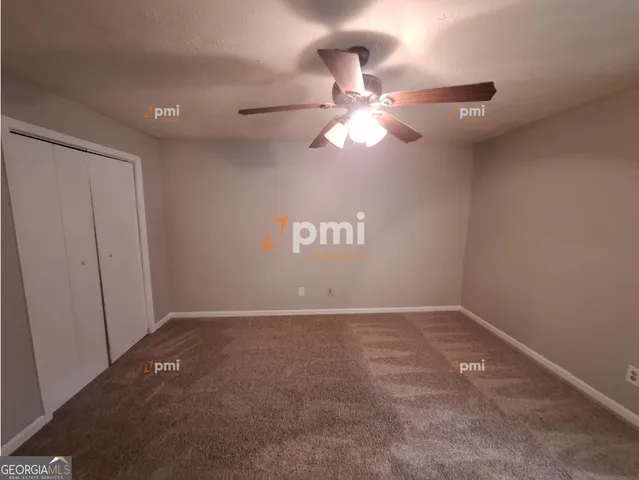 an empty room with a fan & a window