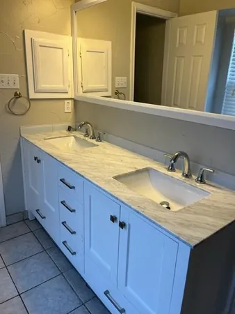 a bathroom with a granite countertop sink and a mirror