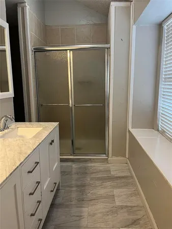 a bathroom with a granite countertop shower sink and mirror