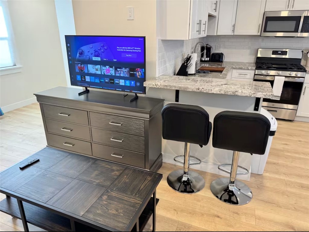 123 6th Street Huntington Beach, CA 92648 - Photo 6 of 7 a kitchen with stainless steel appliances granite countertop a stove a sink and cabinets