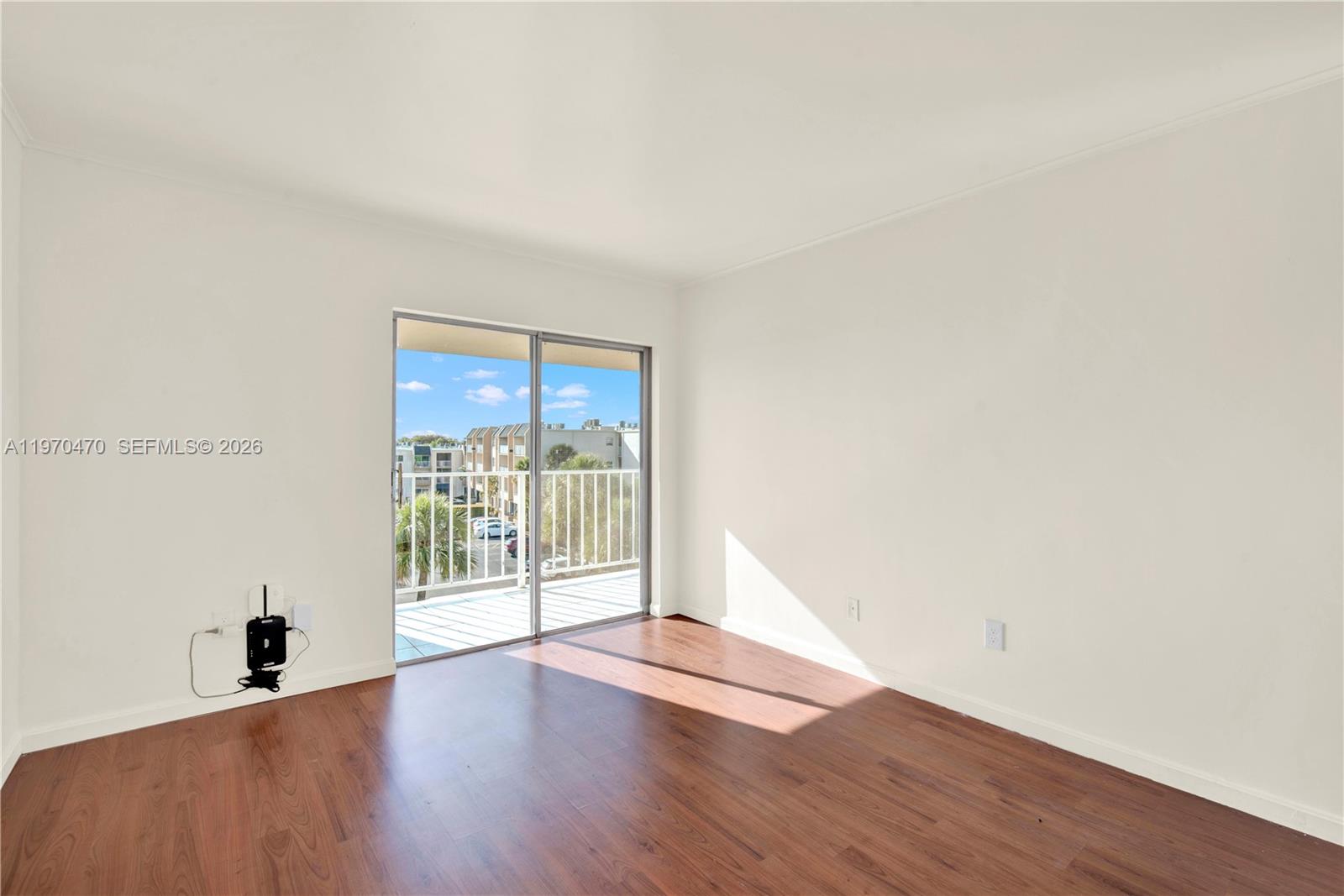 7747 Southwest 86th Street, Unit D403 Miami, FL 33143 - Photo 13 of 25 an empty room with wooden floor and windows