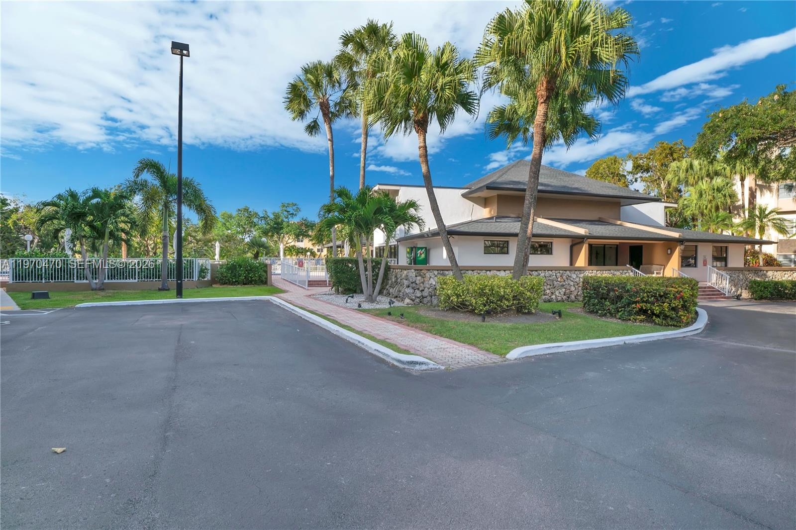 7747 Southwest 86th Street, Unit D403 Miami, FL 33143 - Photo 18 of 25 a view of a house with a yard and palm trees