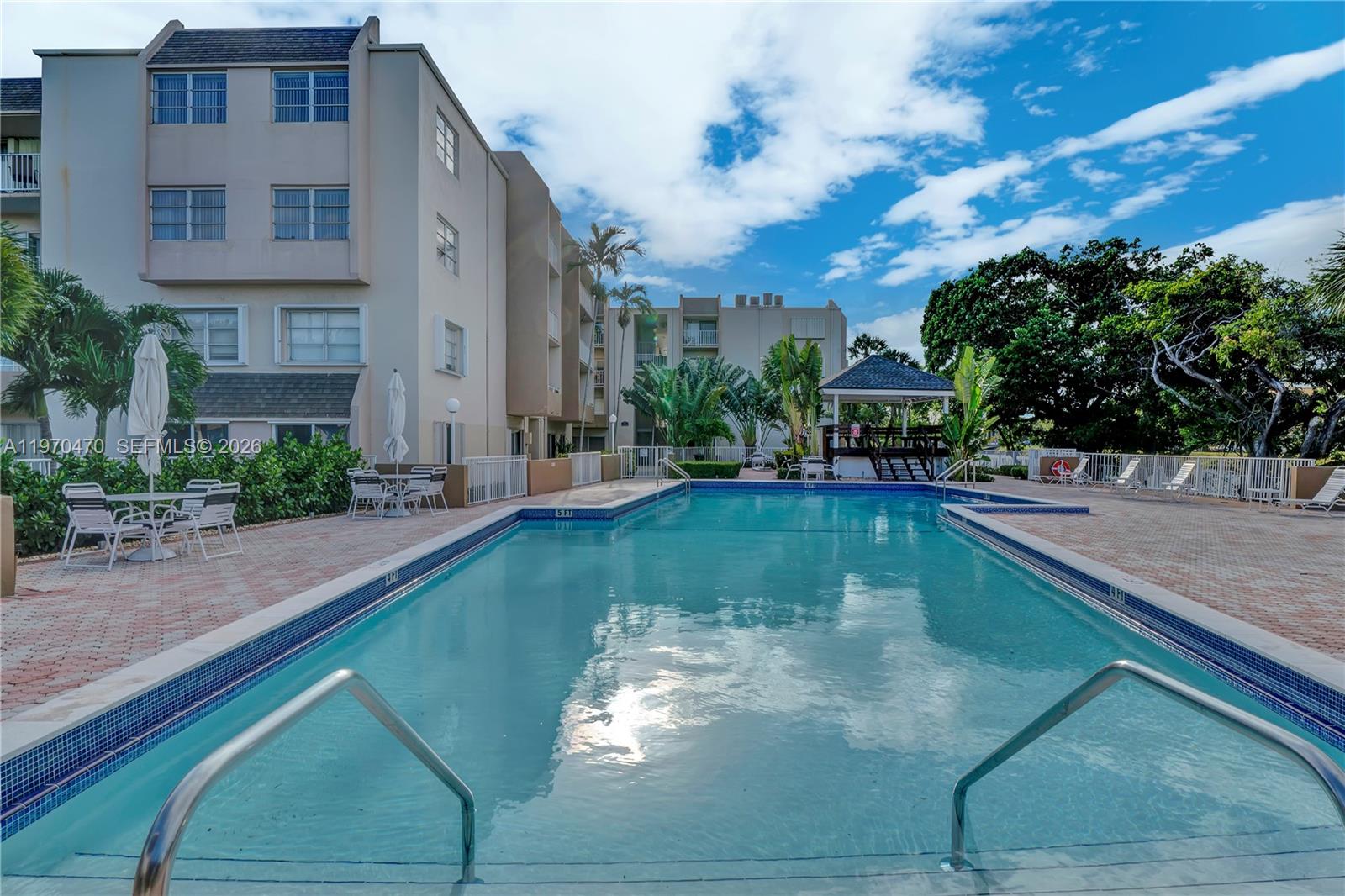 7747 Southwest 86th Street, Unit D403 Miami, FL 33143 - Photo 20 of 25 a view of a swimming pool with a patio