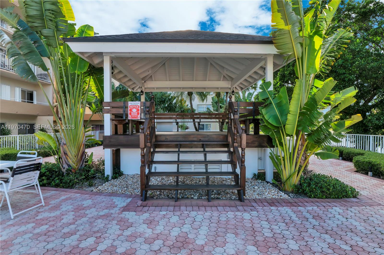 7747 Southwest 86th Street, Unit D403 Miami, FL 33143 - Photo 25 of 25 a view of a patio with a table and chairs under an umbrella