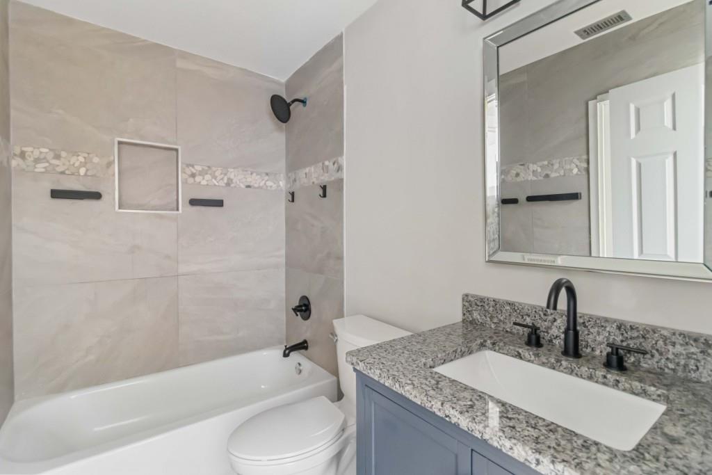 266 Clearview Court, Unit 266 Villa Rica, GA 30180 - Photo 12 of 32 a bathroom with a granite countertop tub sink toilet and mirror