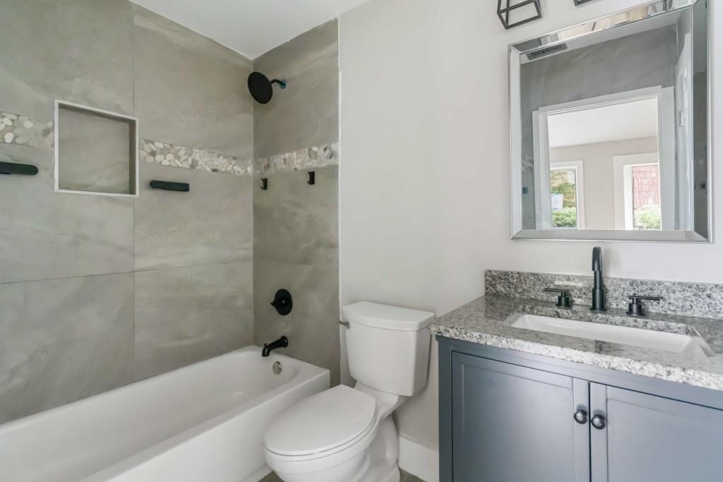 266 Clearview Court, Unit 266 Villa Rica, GA 30180 - Photo 13 of 32 a bathroom with a granite countertop toilet a sink and bathtub