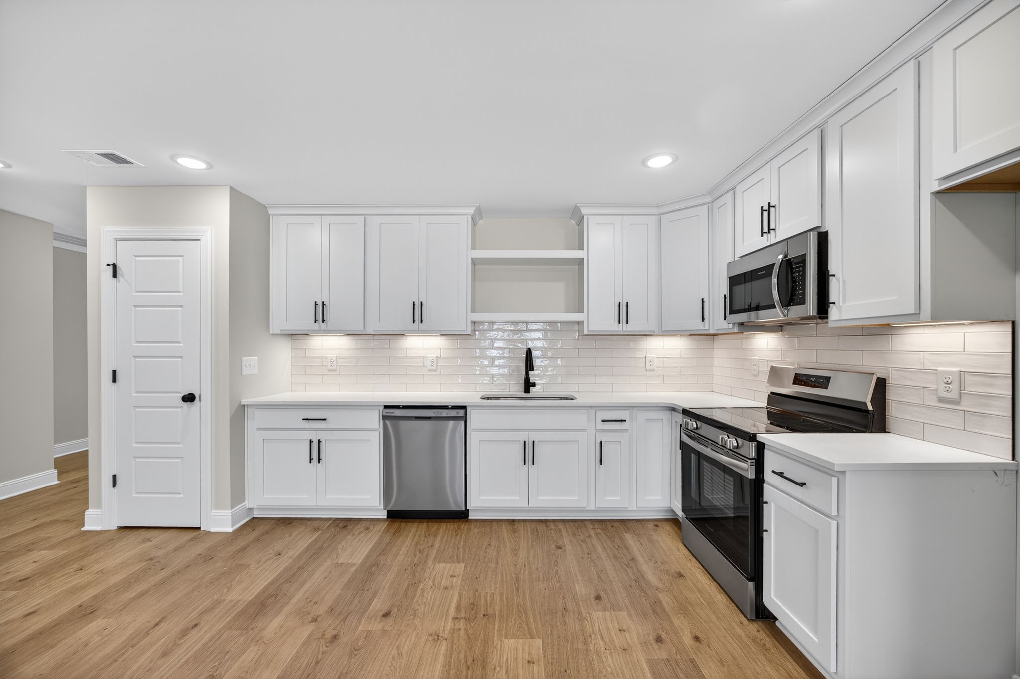 2111 Rylee Way, Unit 9 Greenbrier, TN 37073 - Photo 11 of 33 a kitchen with granite countertop a sink a stove a refrigerator and white cabinets