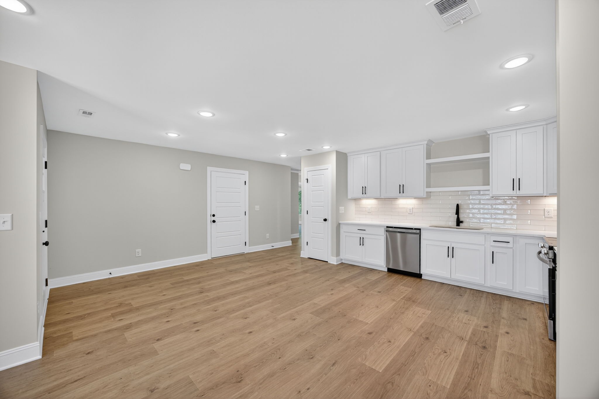 2111 Rylee Way, Unit 9 Greenbrier, TN 37073 - Photo 12 of 33 a large white kitchen with a sink dishwasher a stove and a refrigerator with wooden floor