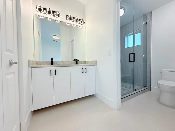 a white toilet sitting next to a shower