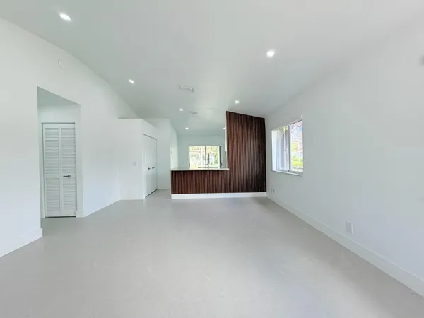 an empty room with windows and cabinet in it