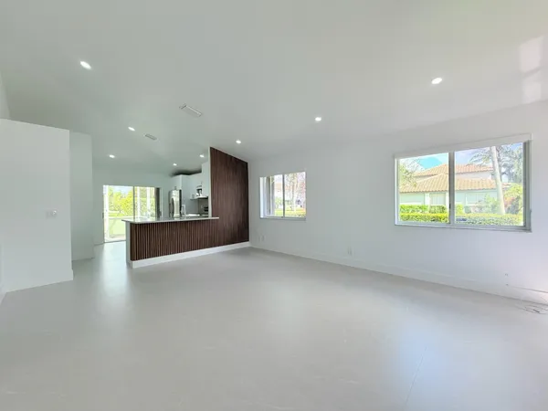 an empty room with windows and fireplace