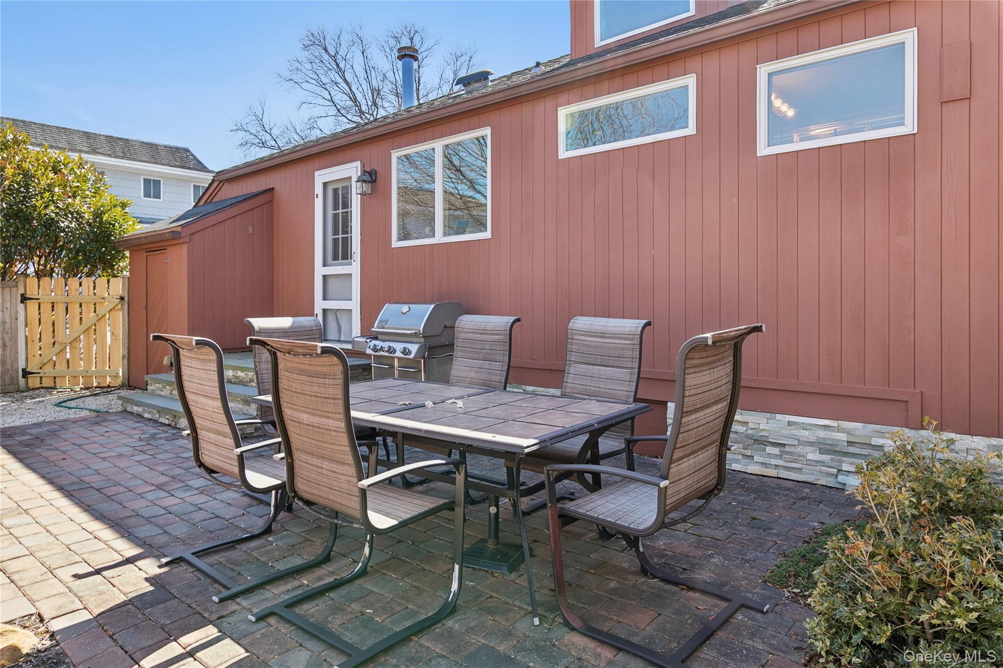 20 Mitchell Road Westhampton Beach, NY 11978 - Photo 22 of 34 a backyard of a house with wooden chairs and wooden floor