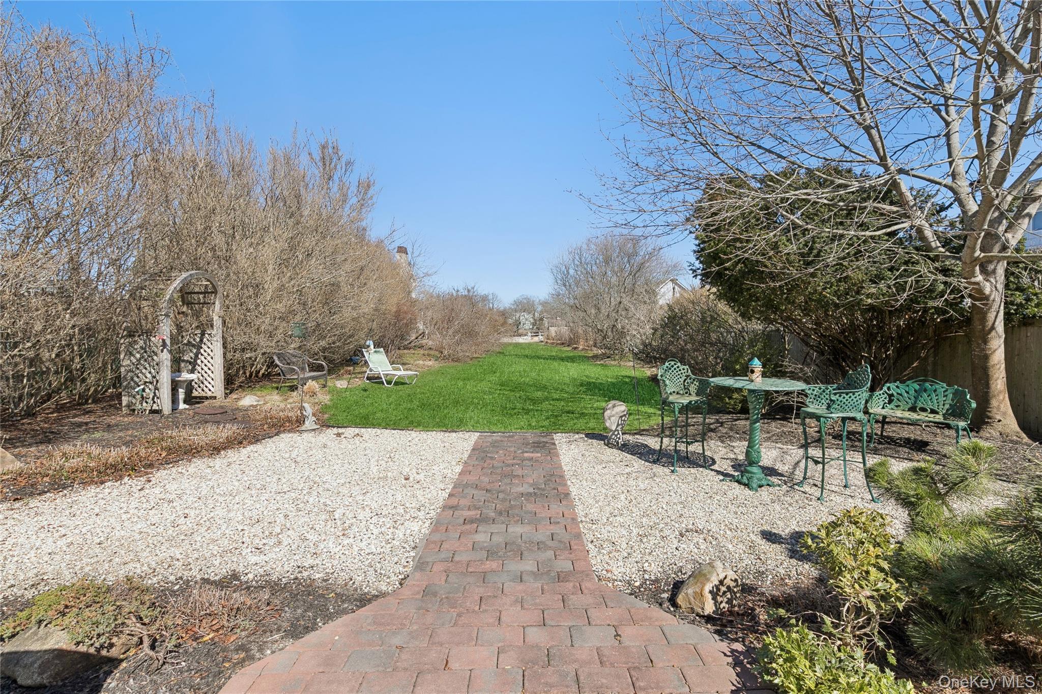 20 Mitchell Road Westhampton Beach, NY 11978 - Photo 23 of 34 a view of backyard with table and chairs and wooden fence