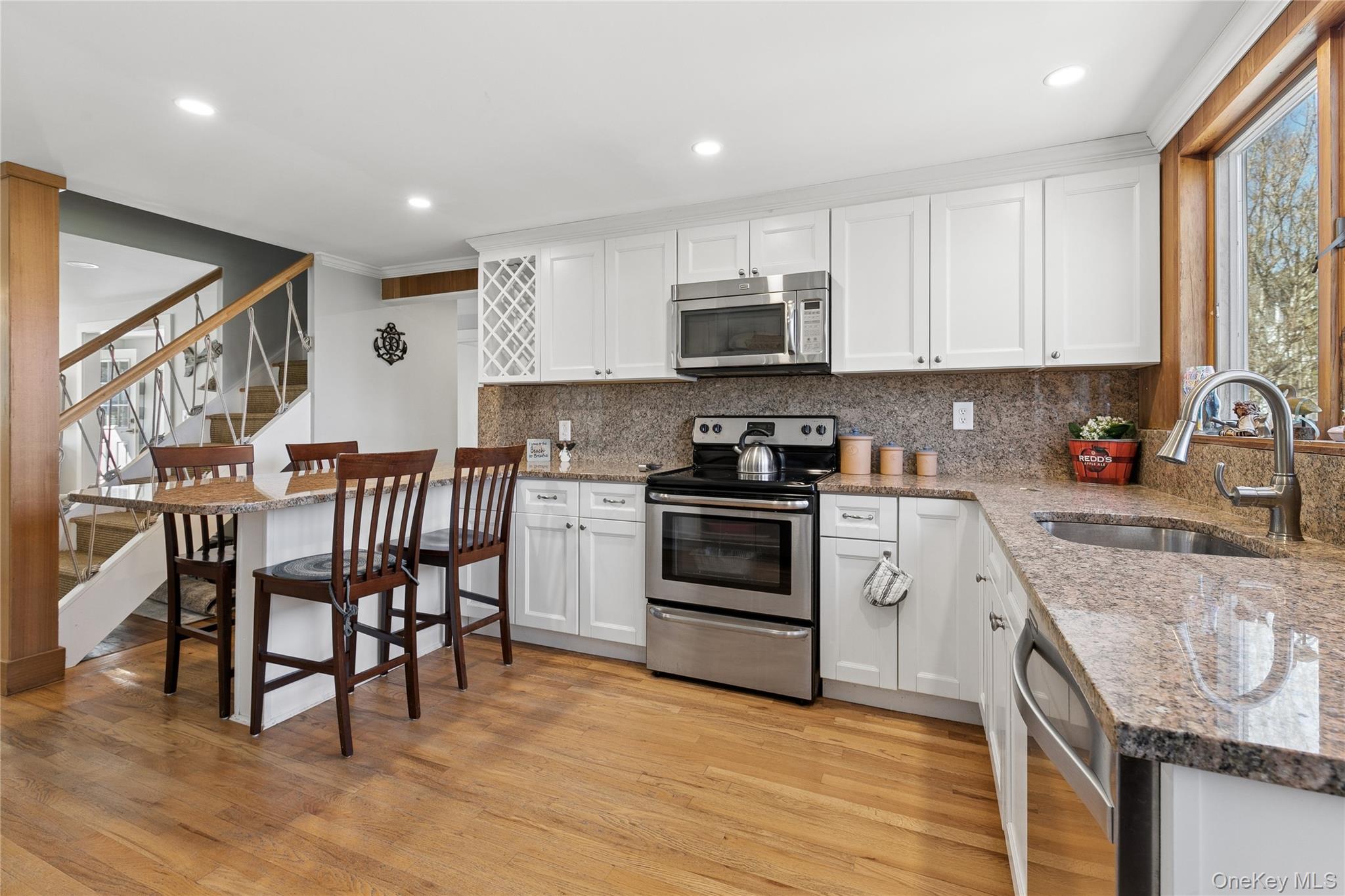 20 Mitchell Road Westhampton Beach, NY 11978 - Photo 8 of 34 a kitchen with stainless steel appliances granite countertop a stove a sink a microwave a refrigerator and cabinets