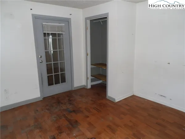 an empty room with wooden floor and closet