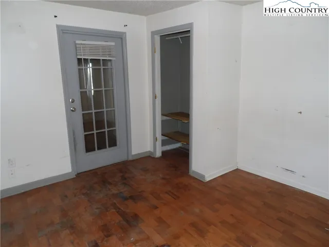 an empty room with wooden floor and closet