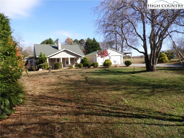 a view of a yard with plants and trees