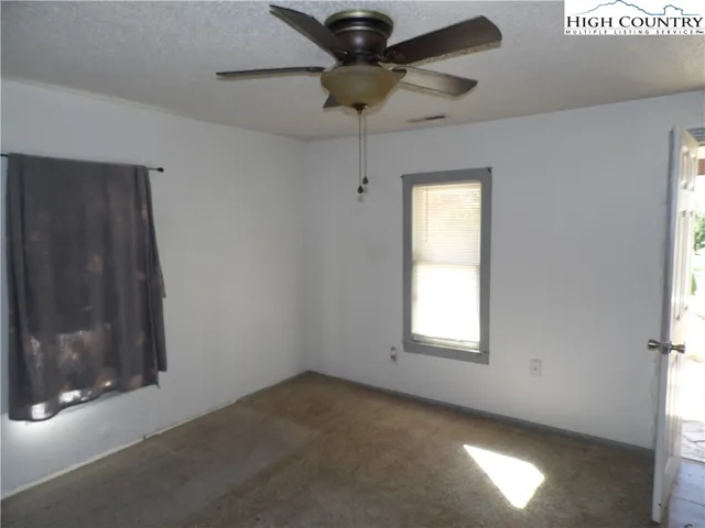 a view of a livingroom with a ceiling fan and window