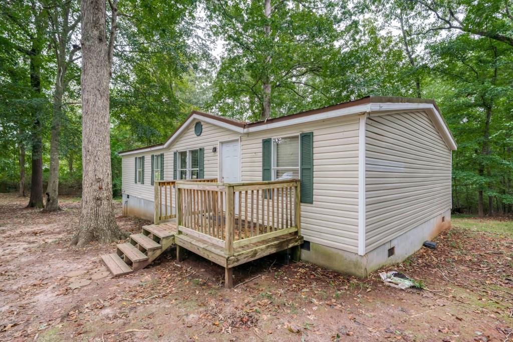 947 Davis Road Jefferson, GA 30549 - Photo 1 of 1 a view of backyard with a small deck and a large tree