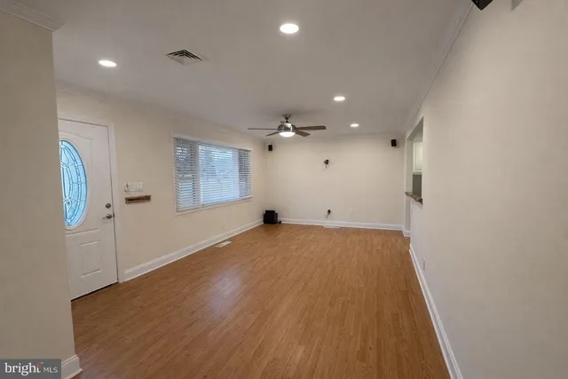 a view of empty room with wooden floor