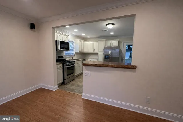 a kitchen with granite countertop a refrigerator and a stove top oven