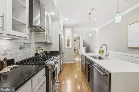 a kitchen with stainless steel appliances a sink a stove a refrigerator and cabinets