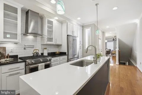 a kitchen with kitchen island stainless steel appliances a dining table and chairs