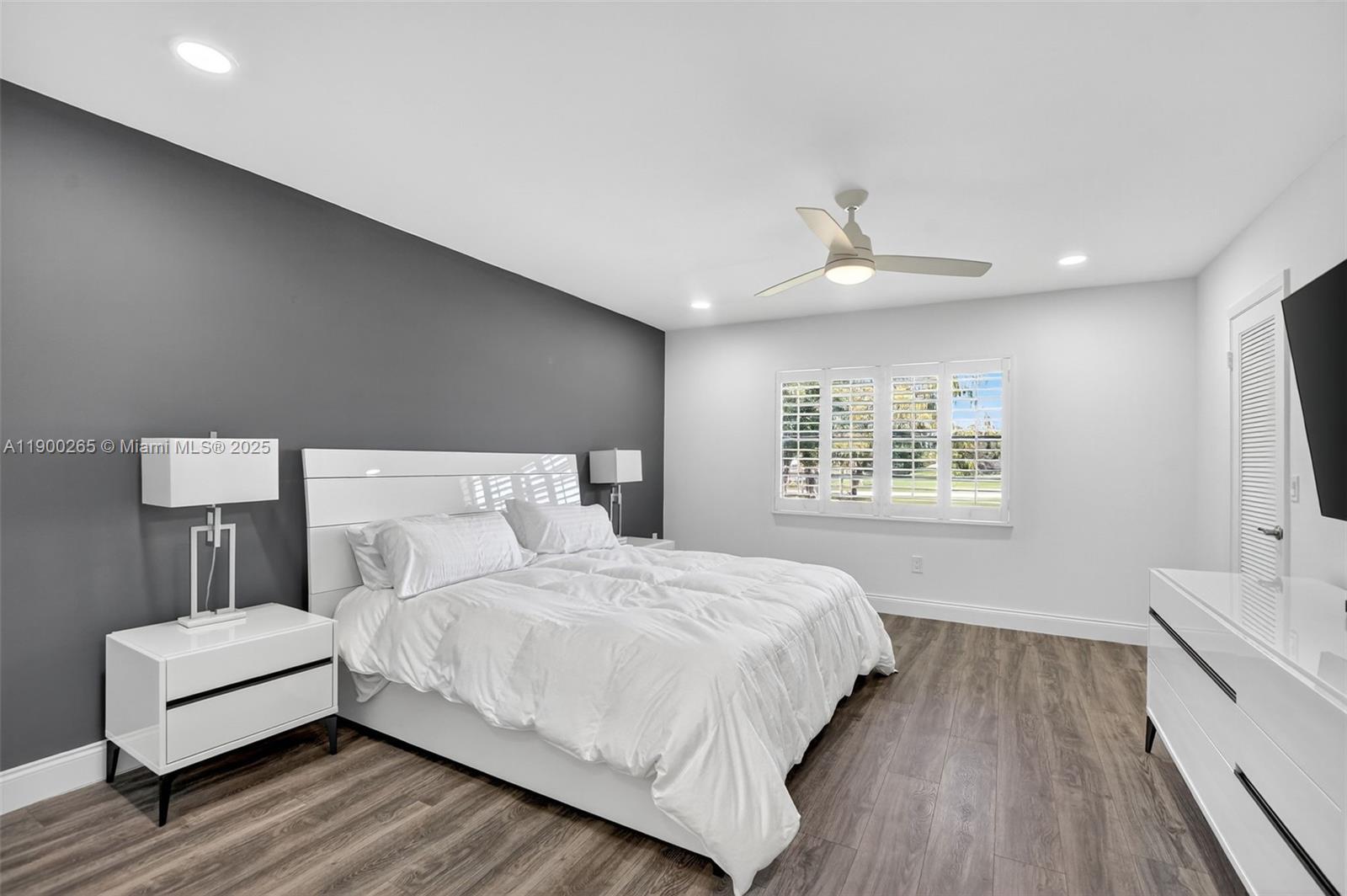 21860 Arriba Real, Unit 4D Boca Raton, FL 33433 - Photo 16 of 55 a bedroom with a large bed chandelier and a window