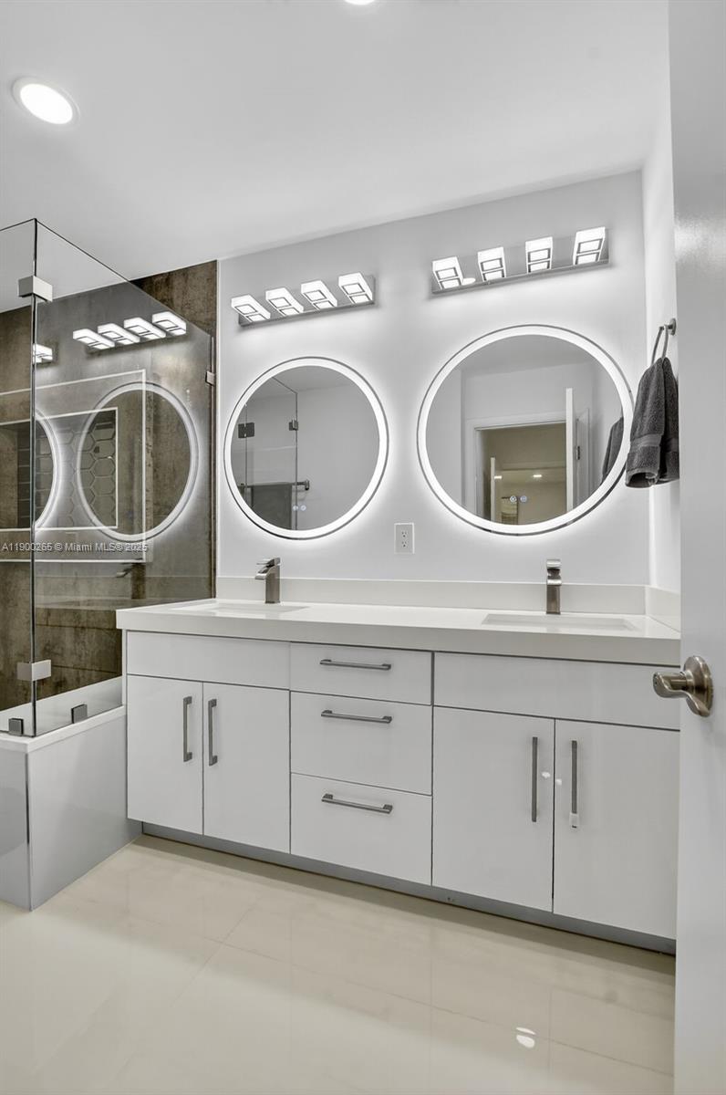 21860 Arriba Real, Unit 4D Boca Raton, FL 33433 - Photo 20 of 55 a bathroom with a double vanity sink a mirror and