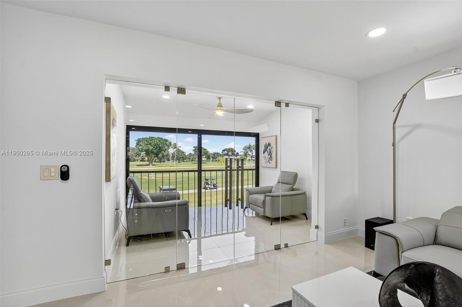 21860 Arriba Real, Unit 4D Boca Raton, FL 33433 - Photo 27 of 55 a living room with furniture and a floor to ceiling window