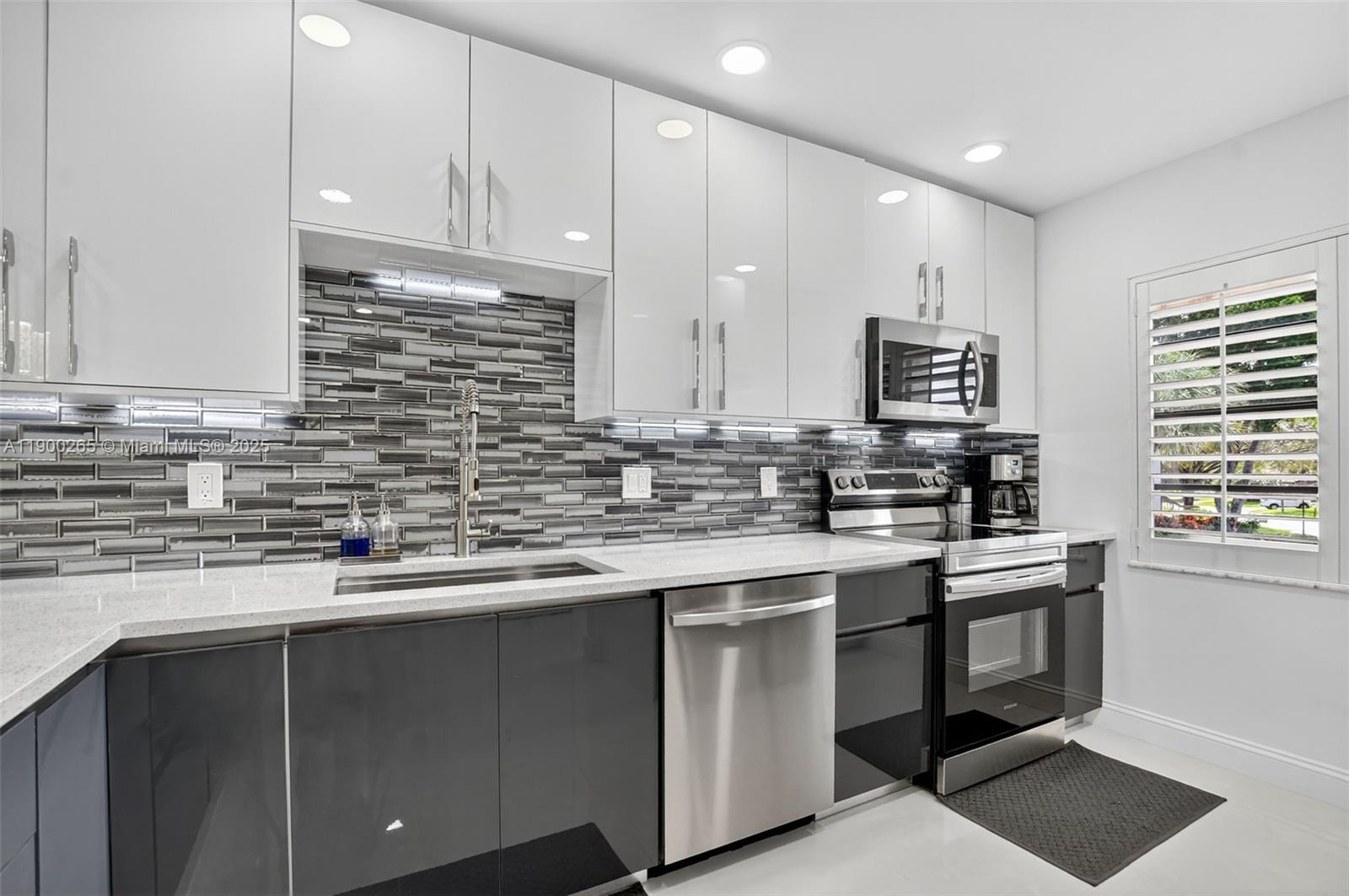 21860 Arriba Real, Unit 4D Boca Raton, FL 33433 - Photo 3 of 55 a kitchen with stainless steel appliances a sink stove and cabinets