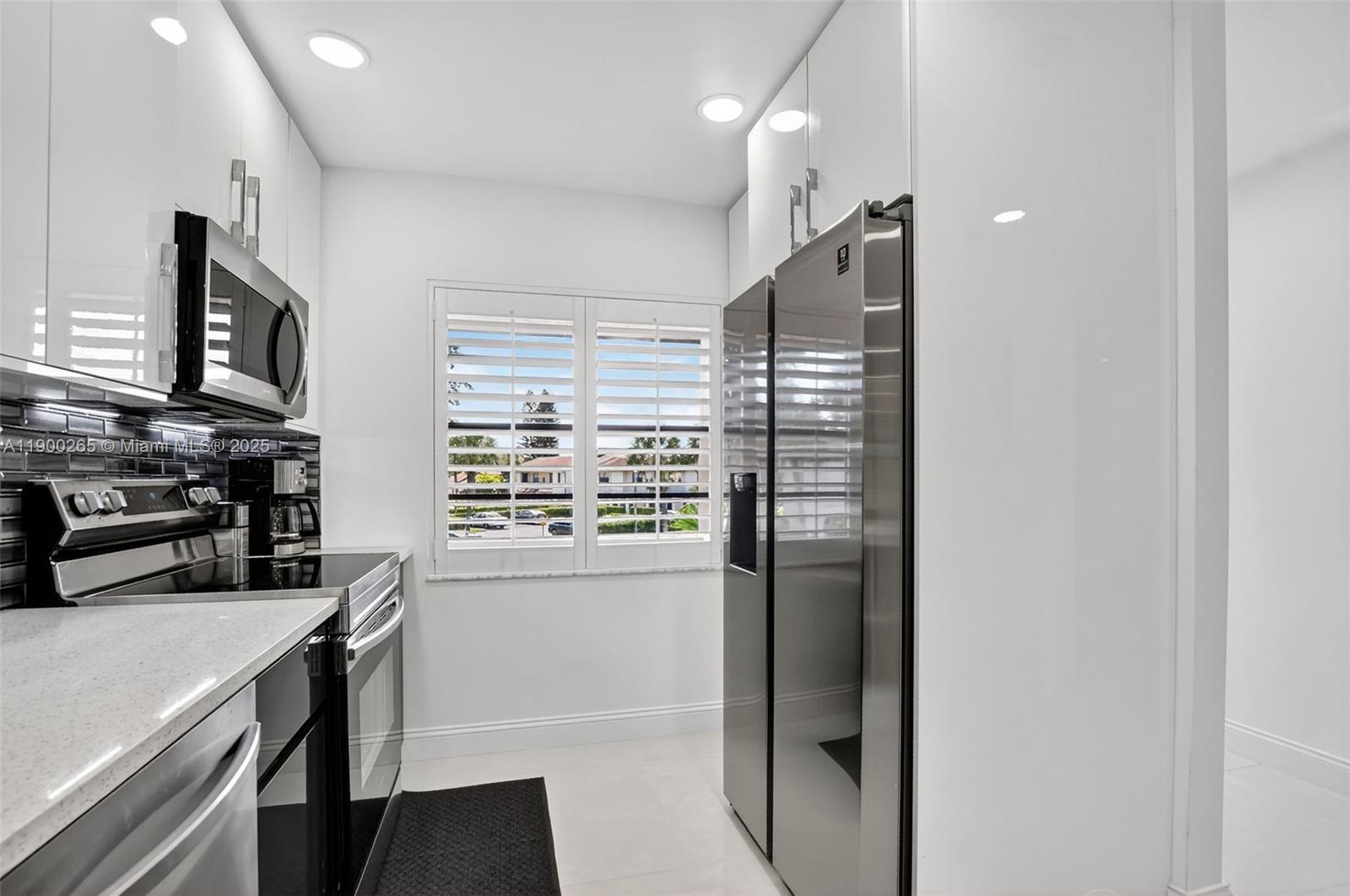 21860 Arriba Real, Unit 4D Boca Raton, FL 33433 - Photo 4 of 55 a kitchen with stainless steel appliances a refrigerator and a stove top oven