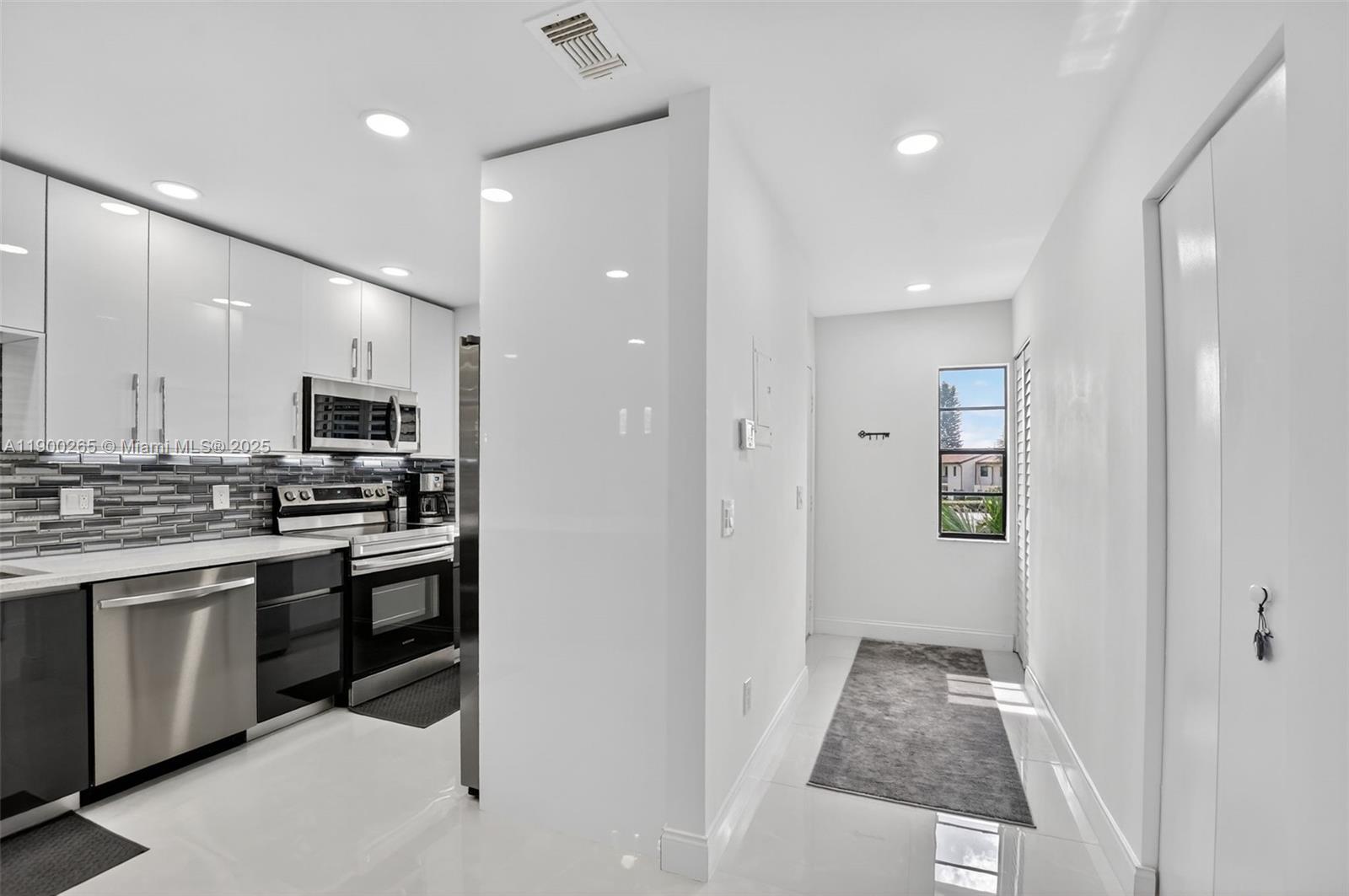 21860 Arriba Real, Unit 4D Boca Raton, FL 33433 - Photo 5 of 55 a kitchen with stainless steel appliances kitchen island sink refrigerator and stove