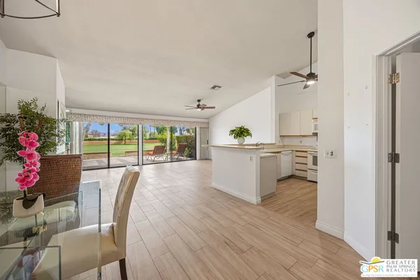 a view of empty room with wooden floor and ceiling fan