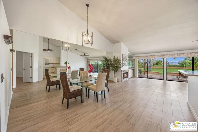 a view of a dining room and livingroom with furniture wooden floor a chandelier