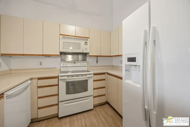 an empty room with wooden floor and fan