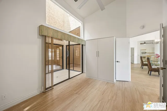 a view of empty room with wooden floor and fan