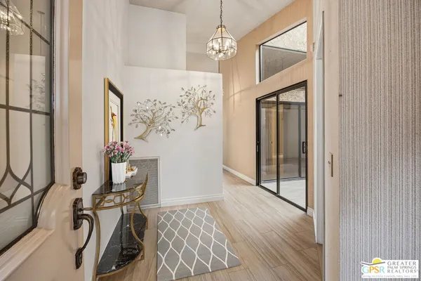 a view of a hallway with wooden floor and a bathroom