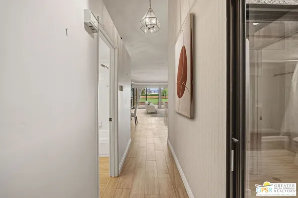 a view of a dining room and livingroom with furniture wooden floor a chandelier