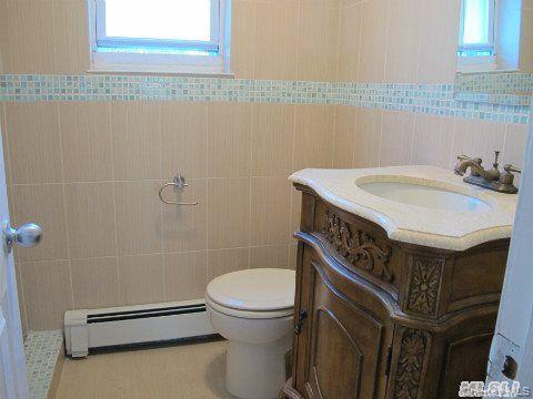 5 Elm Street Great Neck, NY 11021 - Photo 9 of 17 a bathroom with a sink a toilet and a mirror