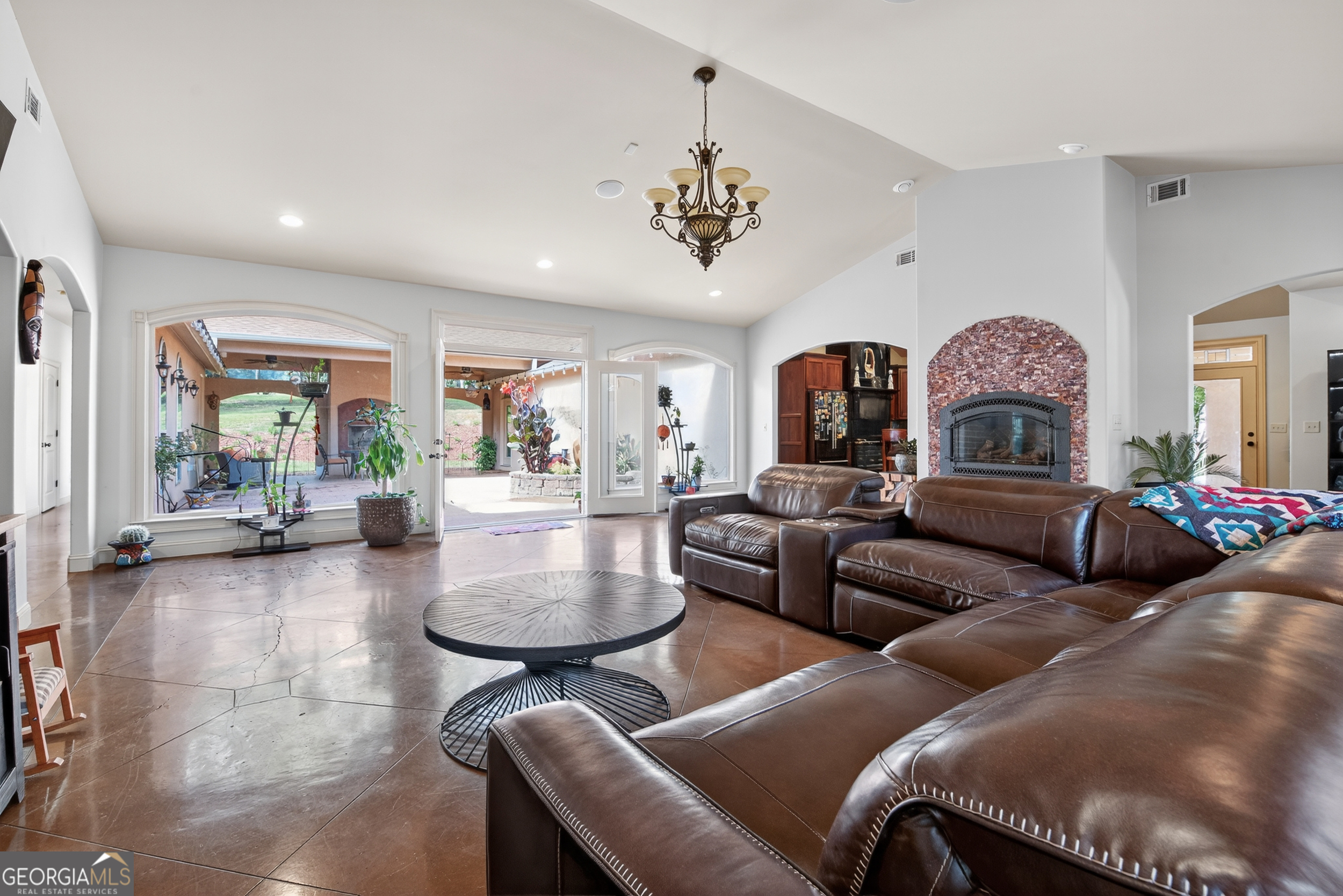 1583 Hickory Flat Road Gillsville, GA 30543 - Photo 9 of 79 a living room with couches a chandelier and kitchen view